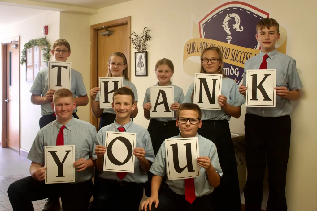 Students holding signs with letters that spell out "Thank You"