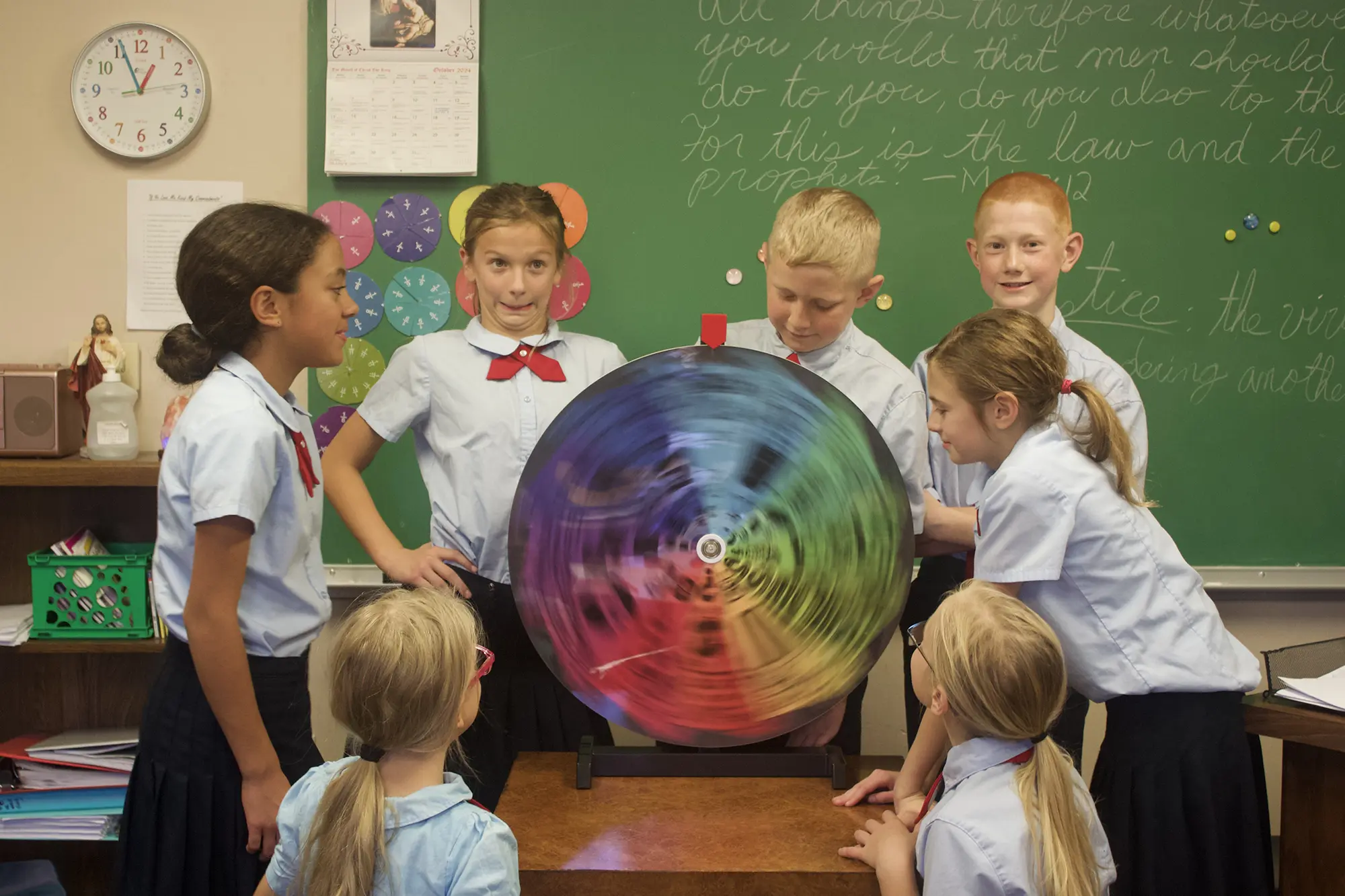 Students standing around a spinning colorful wheel to win a prize