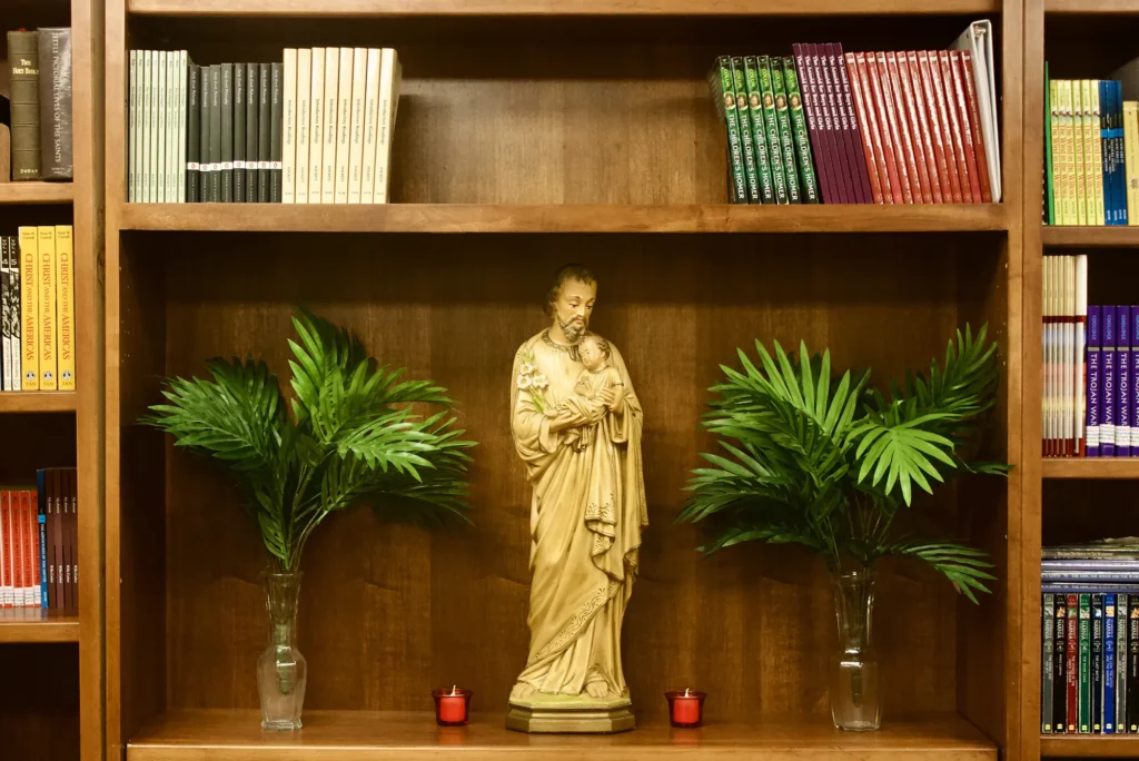 Small figure of a Catholic Saint on a bookshelf