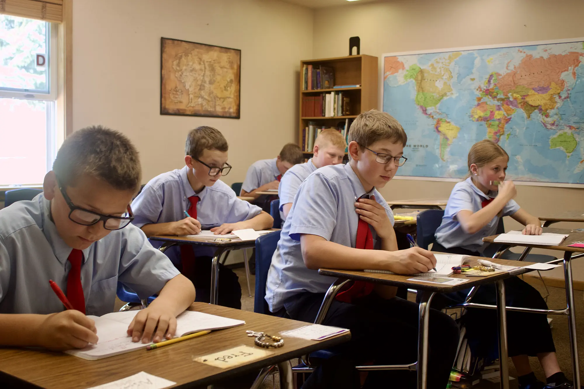 Students writing at desks in class